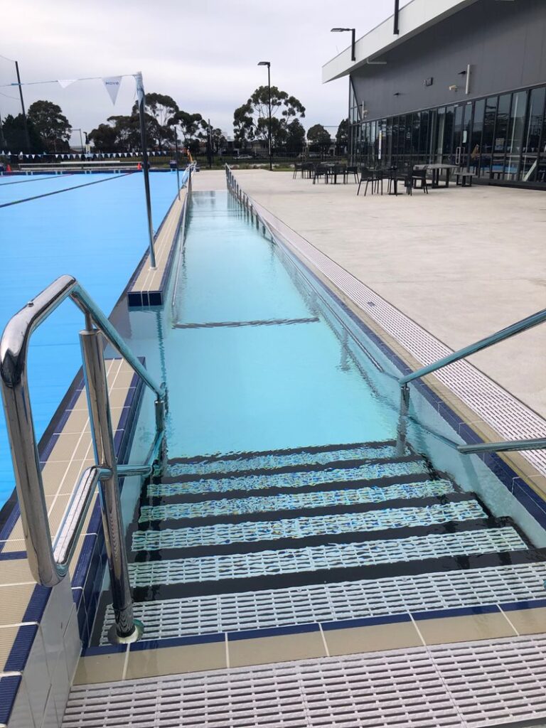 Outdoor 50m heated pool features ramp access with hand rails for step-free entrance